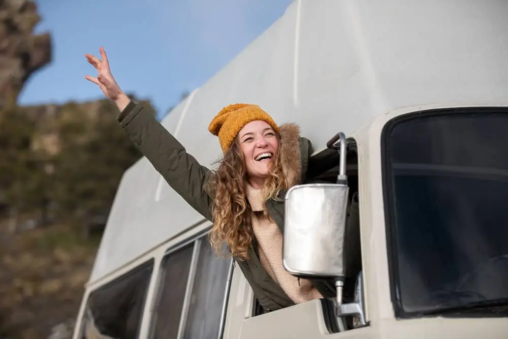 woman waving from RV window